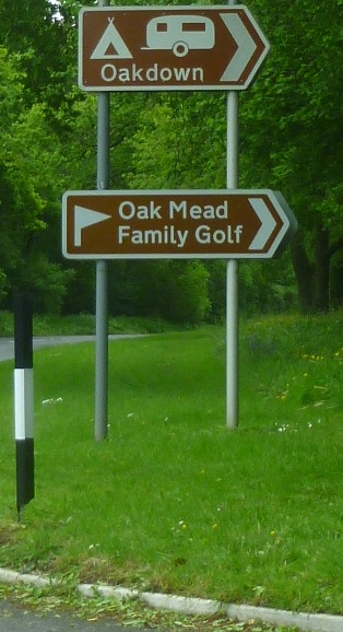 A brown tourist sign for Oak Mead Family Golf Centre