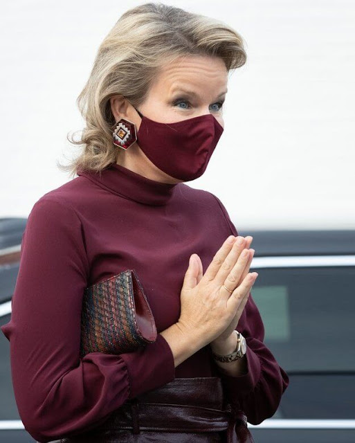Queen Mathilde wore a burgundy, wine red silk blouse from Natan and a burgundy leatherette, imitation leather belted skirt from Natan