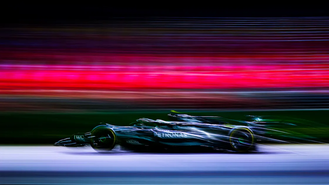 High-Speed Mercedes-Benz Formula 1 Car in Motion Blur against a Vivid Multicolored Backdrop on 4K Wallpaper