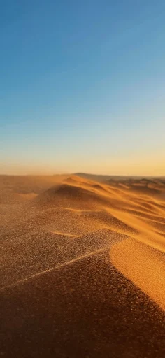 Twilight hues casting shadows on desert dunes wallpaper