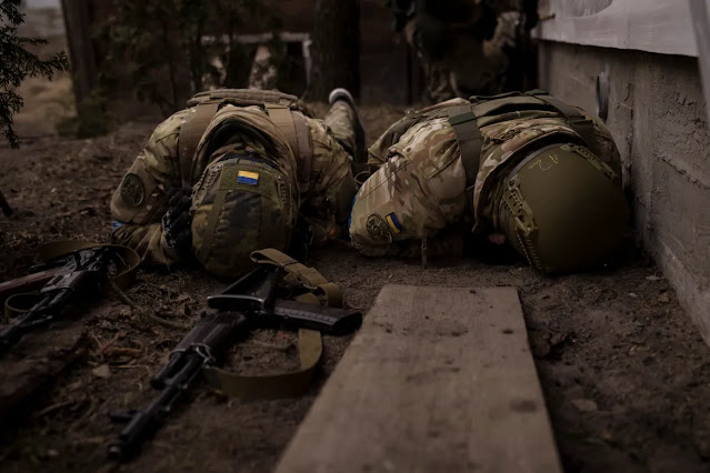Ukrainian soldiers take cover from incoming artillery fire in Irpin, near the Ukrainian capital Kyiv. [Felipe Dana/AP Photo]