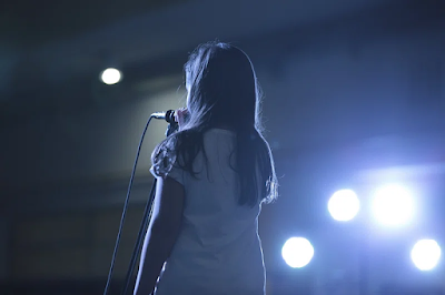 a girl in white holding a mic