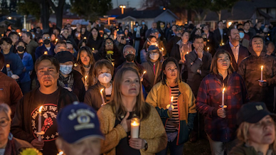 clolor photograph of people gathered at the Monterey Park City Hall for a candlelight vigil honoring 11 victims of a mass shooting in the city on Lunar New Year's Eve.