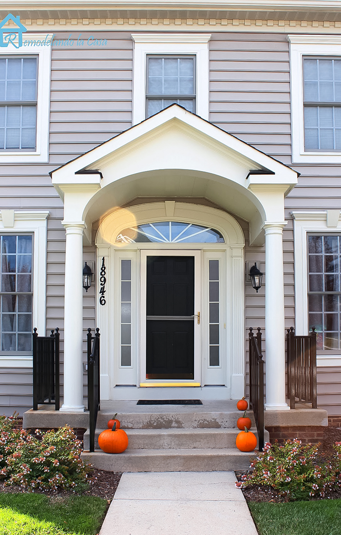 Colonial home with porch & pumpkins on the steps