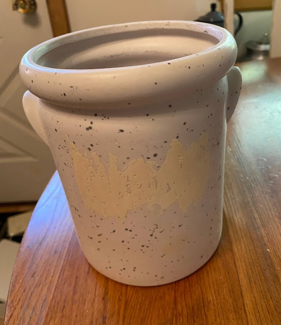 Photo of a crock with etched surface filled with putty.