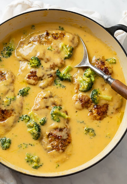 cheesy chicken in a skillet with broccoli.