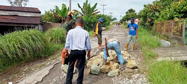 Kompak Personel jajaran Kodim 0207/Simalungun Bersama Masyarakat Gotong Royong Secara Swadaya Penimbunan Jalan Yang Berlobang