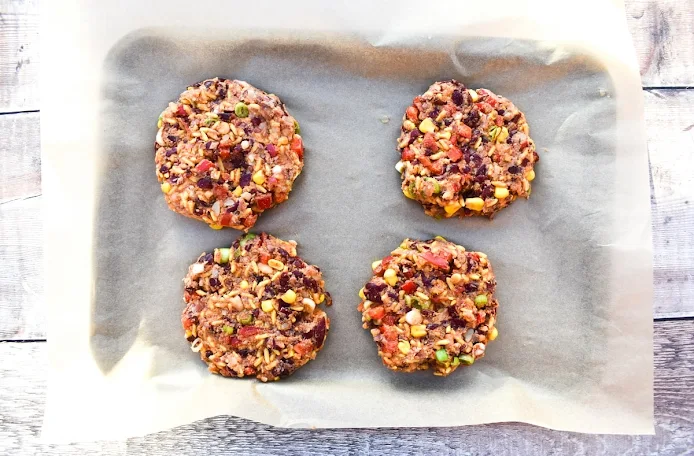 Uncooked Mexican bean burger patties on a baking sheet