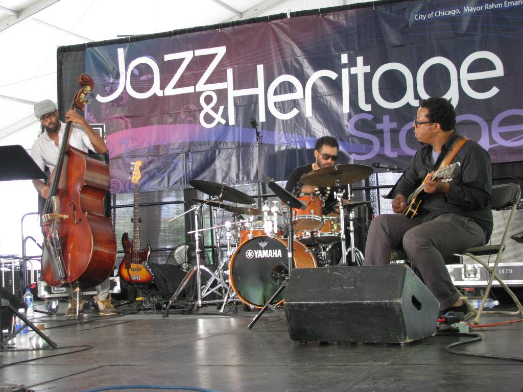 Junius Paul (double bass), Makaya McCraven (drums), and Jeff Parker (guitar) performing at 2015 Chicago Jazz Festival, September 5, Millennium Park's Jazz and Heritage Pavilion