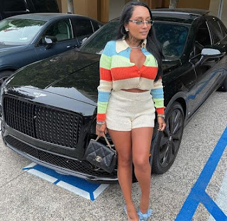 Nia Guzman posing for picture with a car