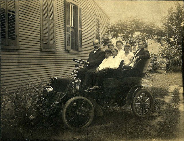 Gente posando con sus coches a principios del siglo XX