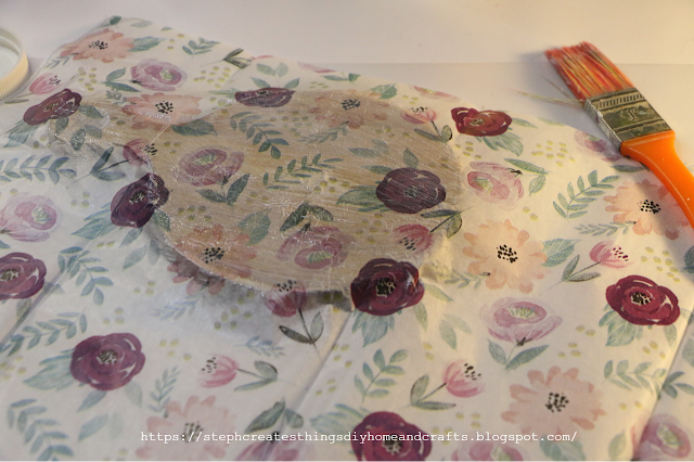 Floral design tissue paper placed over round wooden board