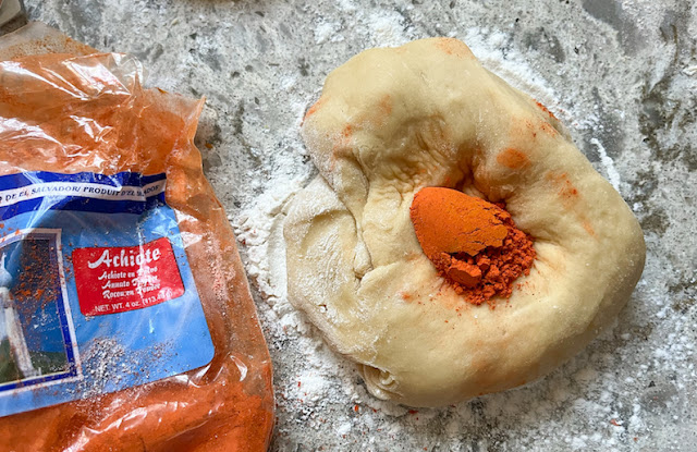 Adding the annatto to the dough ball