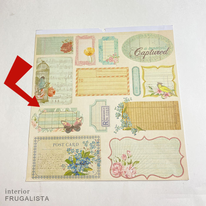 Adding a decoupage scrapbook paper label to the front of the wooden book box makeover.