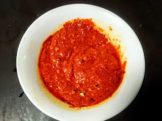Red color chicken Angara kabab masala paste in a mixing bowl