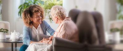 home caregiver chats with elderly woman at home