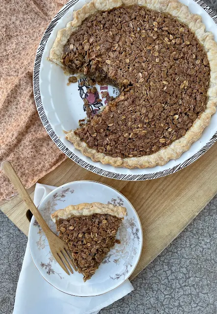 Oatmeal pie with a slice on a serving plate.