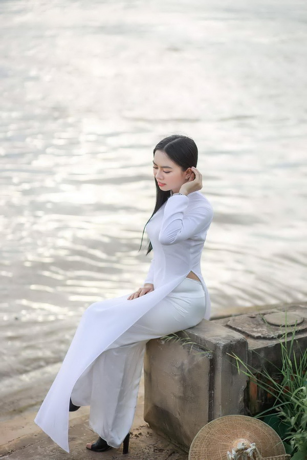 Thiếu nữ áo dài trắng ngồi bờ sông