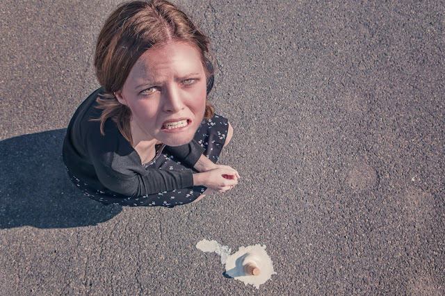 Sad woman and a dropped ice cream cone