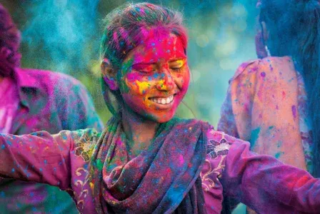 a young girl covered with paint smiling and dancing