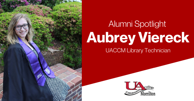 Alumni Spotlight, Aubrey Viereck, UACCM Library Technician. Aubrey is pictured in a graduation gown in front of some greenery.