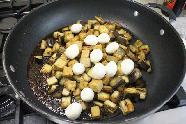 Adding the eggplant, tofu and eggs to the pan