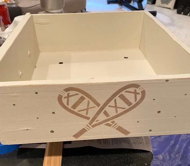 Photo of a drawer side stenciled with a snowshoe stencil.