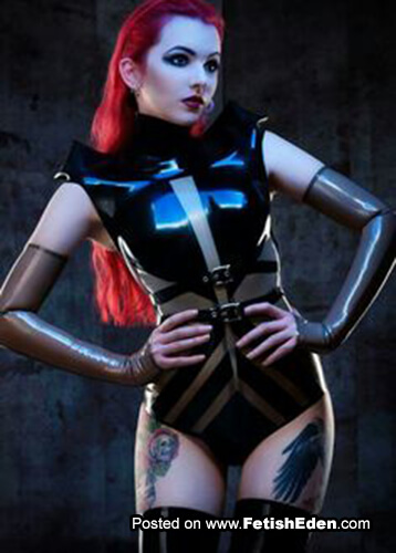 Sexy tattooed redhead with translucent gauntlets wears black latex body