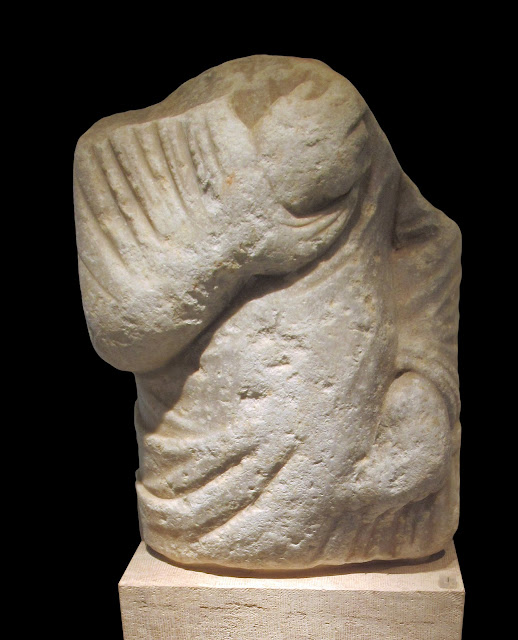 Ημίτομο μαρμάρινο επιτύμβιο άγαλμα ιματιοφόρου που σώζεται ακέφαλο. Παλαιά αρχαιολογική συλλογή. 2ος – 3ος αι. μ.Χ.