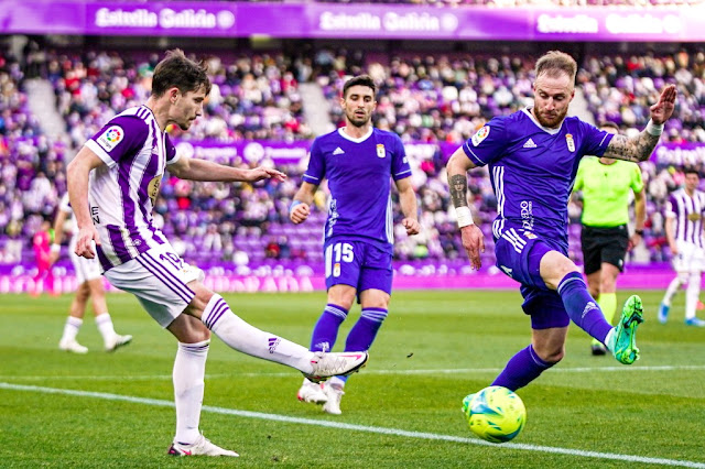 Toni Villa dispara con la oposición de Cornud, ante la mirada de Brugman. REAL VALLADOLID C. F. 2 REAL OVIEDO 1 Domingo 12/12/2021, 16:00 horas. Campeonato de Liga de 2ª División, jornada 20. Valladolid, estadio José Zorrilla