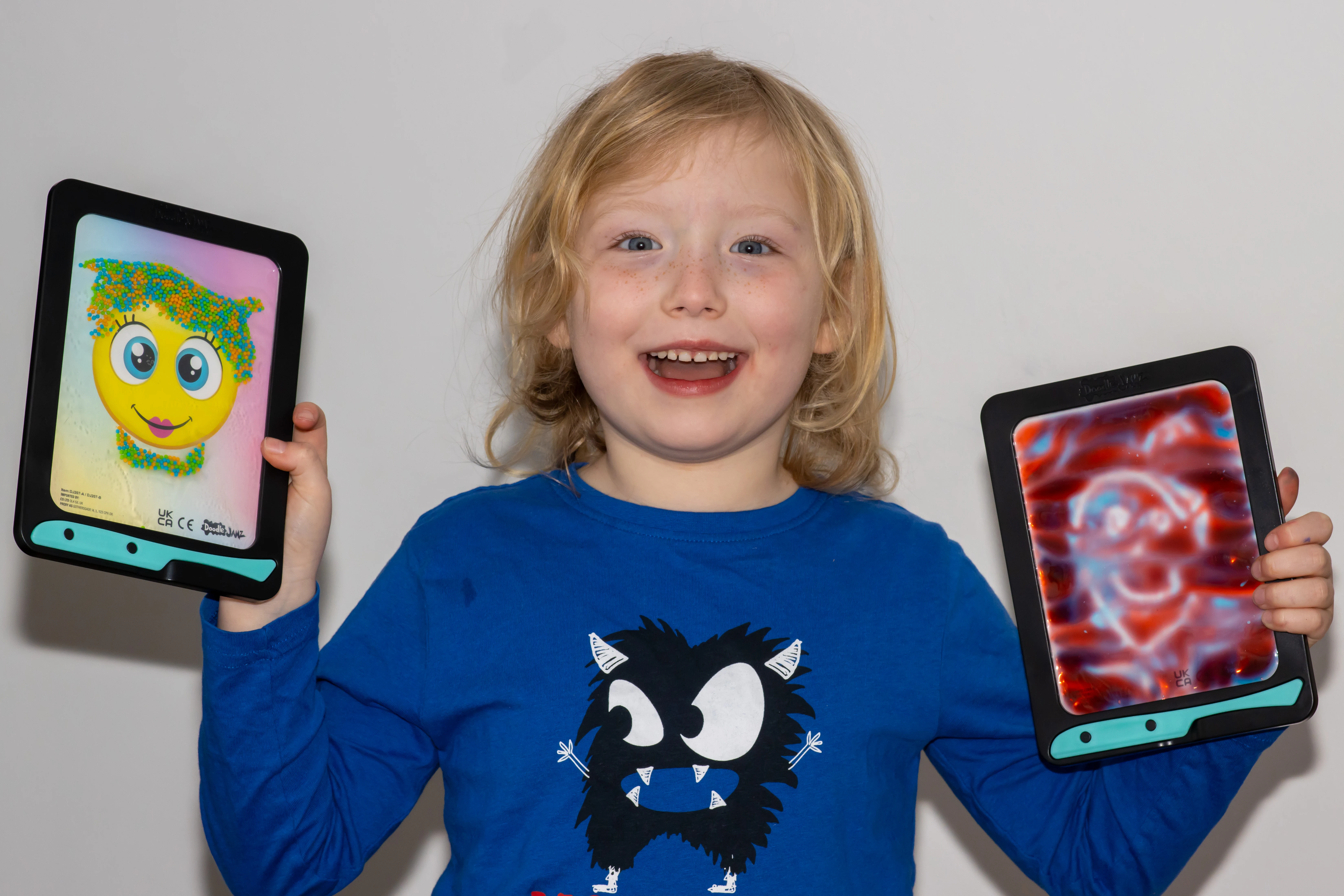 A 6 year old girl holding up DoodleJamz boards showing the Jellypic and Jellyboard