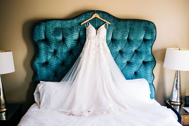 dress hanging on blue bed headboard