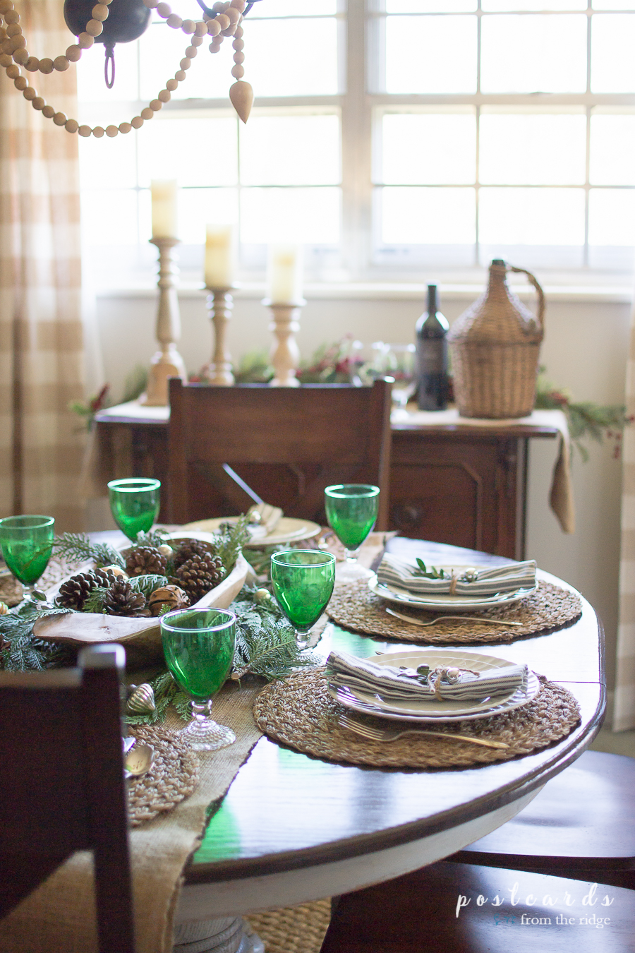 green goblets and natural decorations on Christmas table