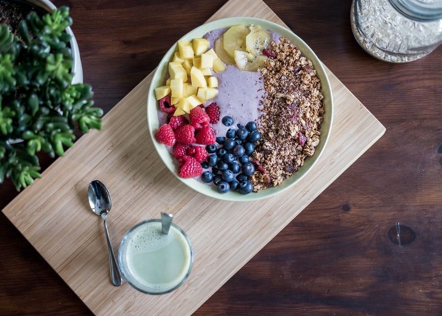 A weight loss breakfast including berry,grapes and milk served on a woodjng serving tray