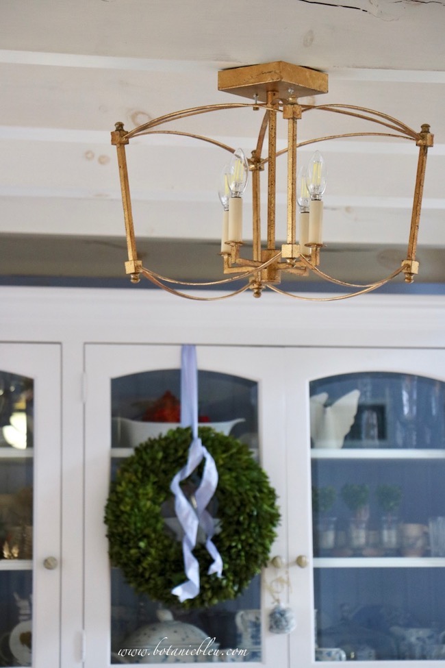 A gorgeous semi-flush antique gold metal light fixture adds the perfect French Country style.