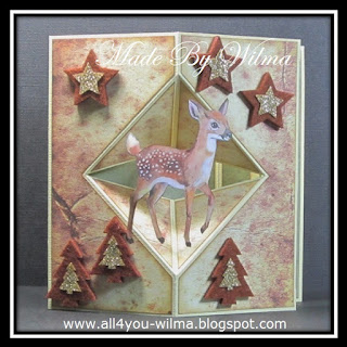 Een kerstkaart met bruine sterren en bruine kerstbomen van vilt met daarbovenop gouden glitter sterren en kerstbomen en een plaatje van een hert. A Christmas card with brown stars and brown felt Christmas trees with gold glitter stars and Christmas trees on top and a picture of a deer.