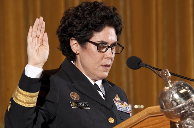 Susan Orsega holds up a hand to take the oath of office.