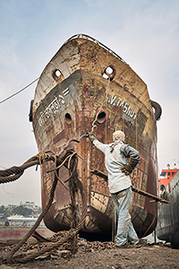 A welder rests in front of a ship at the Dhaka shipyards, Bangladesh 2023