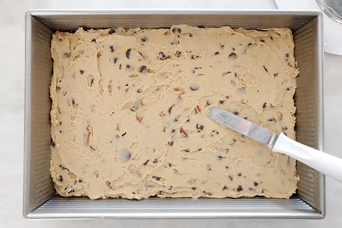 chocolate chip pecan buttermilk cookie bar batter spread in baking pan
