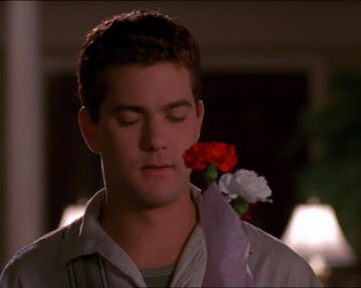 Pacey holding a flower and looking sad