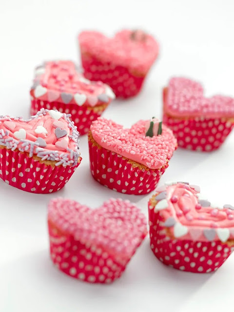 cupcakes with pink frosting on a white background.