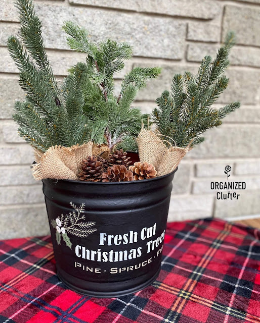 Photo of a metal bucket upcycled with Christmas stencils from Old Sign Stencils, and a decor transfer from Redesign with Prima.