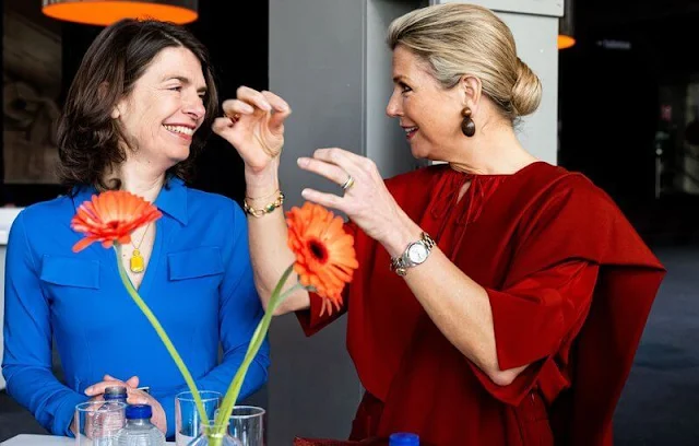 Queen Maxima wore a red silk blouse and red wide-leg trousers. Gianvito Rossi red pumps and Monies earrings. Dutch Council for Refugees