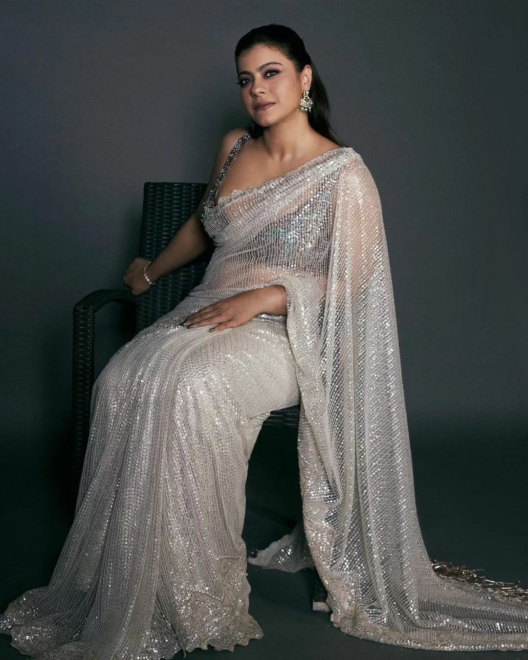 "Bollywood actress Kajol Devgan wearing a sleeveless sequin saree blouse with a plunging neckline."