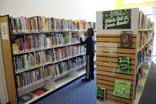 boy checking out books at the library