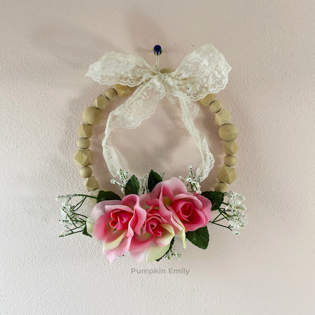 DIY wood bead wreath with pink flowers and a lace bow