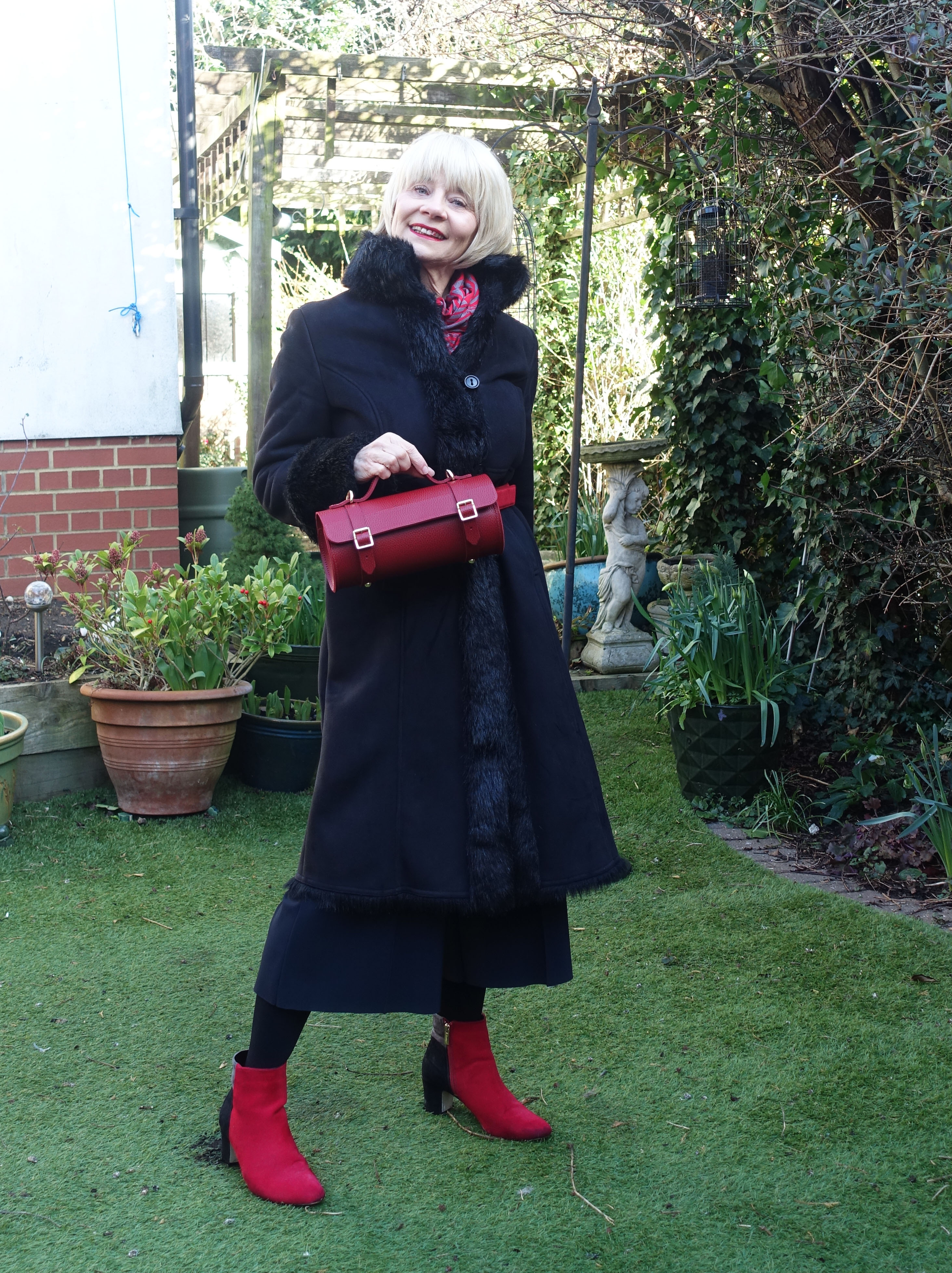 Classic black coat with red accessories including a cute red leather bowls bag from The Cambridge Satchel Company, the choice of Is This Mutton blog in the Style Not Age Challenge If I Were a Handbag.