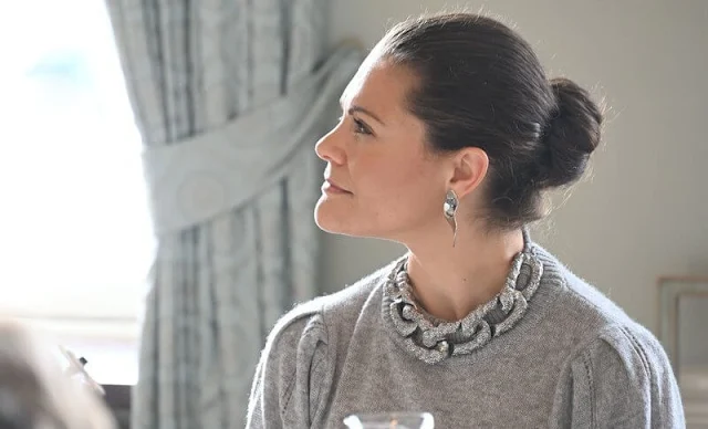 Crown Princess Victoria wore a grey cashmere knit jumper by H&M rhinestone detail necklace. H&M trousers and cape