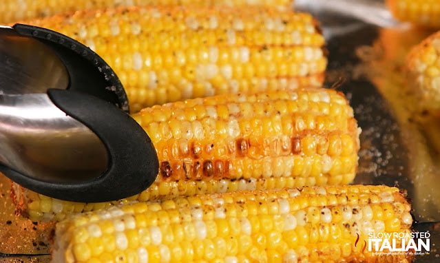 Oven Roasted Corn on the Cob turning with tongs