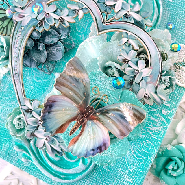 Mixed media canvas created with: Prima Marketing lace paper flowers, coffee break, Zella teal, magical love, finnabair jade impasto paint, grungy succulents, bindweed stencil; Reneabouquets patina lilac chipboard heart frame, into the mystic butterflies, gawdie girl glitter glass in ocean